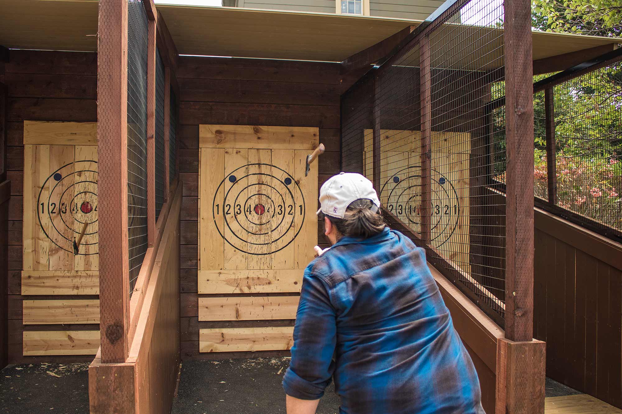 A guest throwing an axe at the target at the winchester mystery house