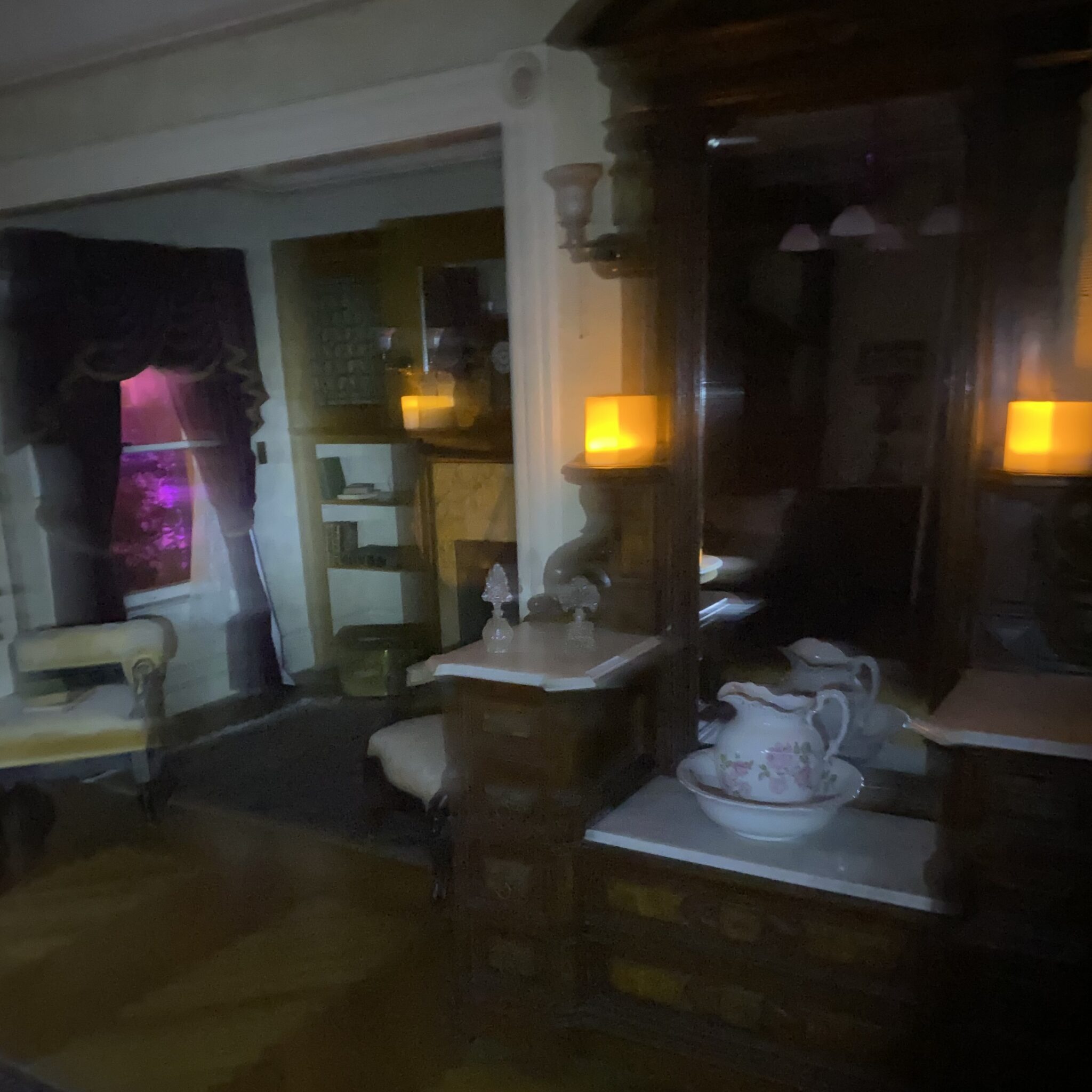 This photo was shared by Jennifer T. from California, taken during the 2020 Halloween flashlight tour. She took several pictures in one room and noticed what looks like a face or head, possibly covered with a shawl, in the back mirror on the left side.